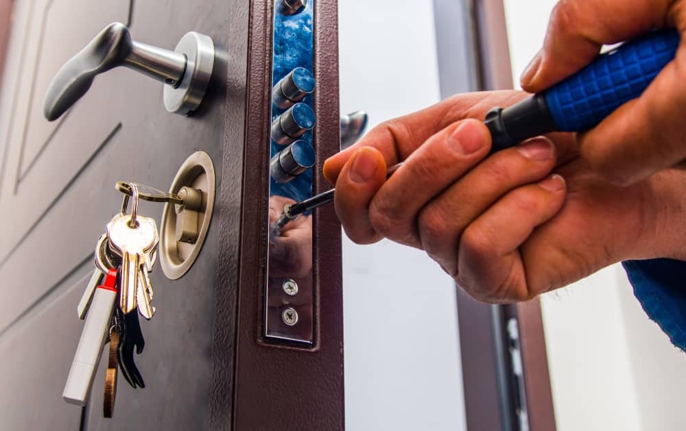 Closeup of locksmith screwing a door lock into place